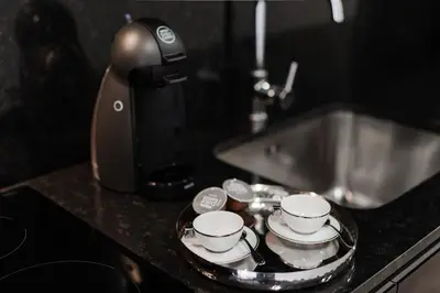 a kitchen counter with a sink and four cups on a tray at Urban Luxury Apartment, Downtown Porto near Metro in Porto