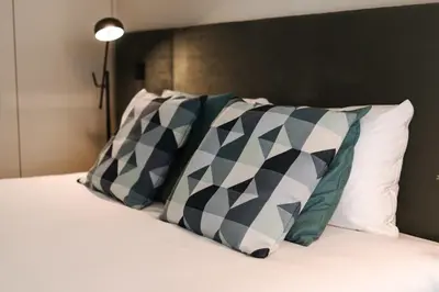 a bed with two pillows and a headboard with at City Luxury Apartment, Downtown Porto near Metro in Porto