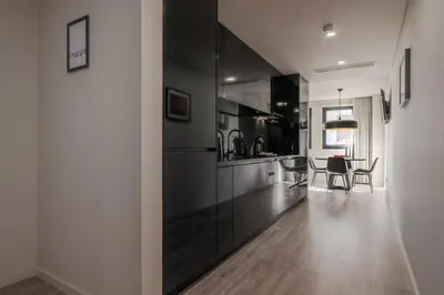 a kitchen with black cabinets and a dining table at City Luxury Apartment, Downtown Porto near Metro in Porto