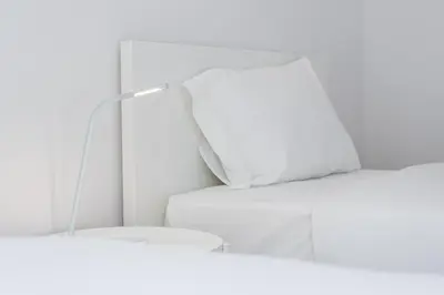 two white beds in a room with a mirror at GuestReady - Artsy Apartment in Porto