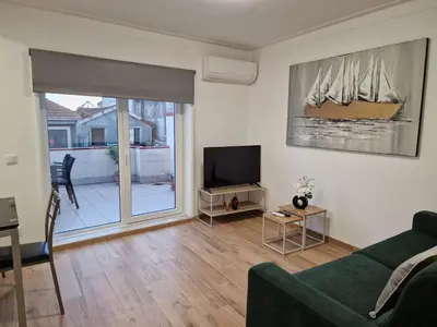a living room with a green couch and a tv at Pretty flat with terrace, air cond, free parking, by Porto with Love LDA in Porto