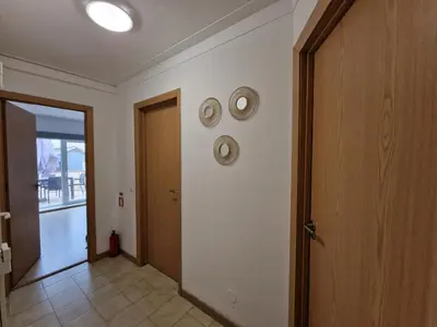 a hallway with two clocks on the wall and a door at Pretty flat with terrace, air cond, free parking, by Porto with Love LDA in Porto