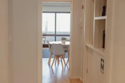 a dining room with a table and a white chair at Downtown Design Apartment With Balcony by Vacationy in Porto