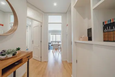 a white hallway with a table and a mirror at Downtown Design Apartment With Balcony by Vacationy in Porto