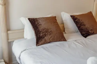 a white bed with two brown pillows on it at Downtown Grand Tower View by Vacationy in Porto