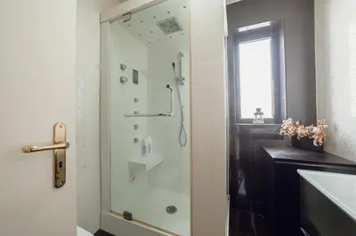 a shower with a glass door in a bathroom at Downtown Grand Tower View by Vacationy in Porto
