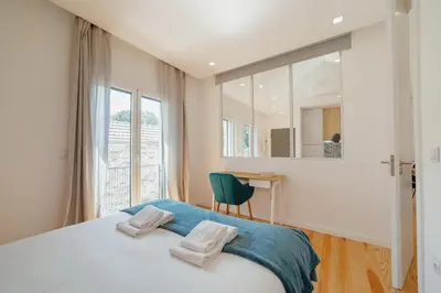 a bedroom with a bed and a desk and a window at Courtyard Oporto Design Apartments by Vacationy in Porto