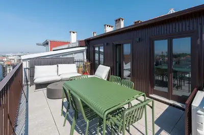 a patio with a green table and chairs on a balcony at Boavista Penthouse w/ 2 Balconies & AC by LovelyStay in Porto