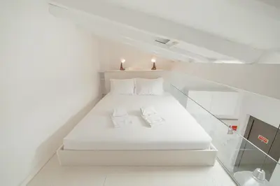 a white bed in a white room with two pillows at Mezzanine Stylish Apartments by Vacationy in Porto