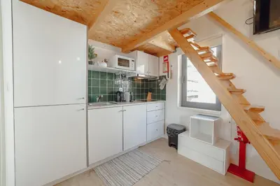 a kitchen with white cabinets and a staircase at Mezzanine Stylish Apartments by Vacationy in Porto