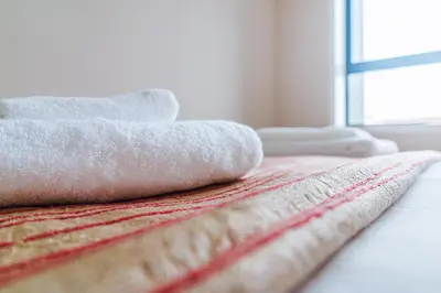 a pile of towels sitting on top of a bed at Emotions Porto Flat in Porto