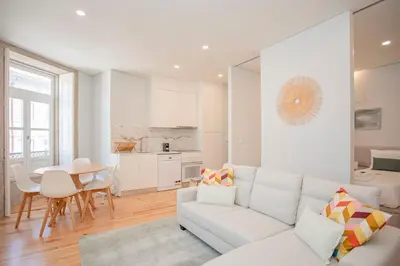 a white living room with a white couch and a table at Liiiving in Porto - Aliados Stone Apartment in Porto