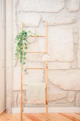 a bamboo towel rack with a plant on it at Liiiving in Porto - Aliados Stone Apartment in Porto