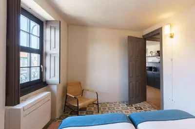 a bedroom with a bed and a window and a chair at Feel Porto Antique Poveiros Flats in Porto
