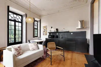a living room with a white couch and a kitchen at Feel Porto Antique Poveiros Flats in Porto