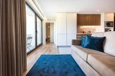 a living room with a couch and a blue rug at Paraíso Apartment in Porto