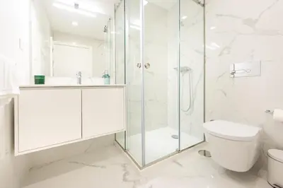 a white bathroom with a shower and a toilet at Paraíso Apartment in Porto