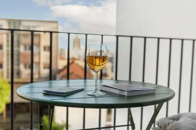 a glass of wine sitting on a table on a balcony at Paraíso Apartment in Porto
