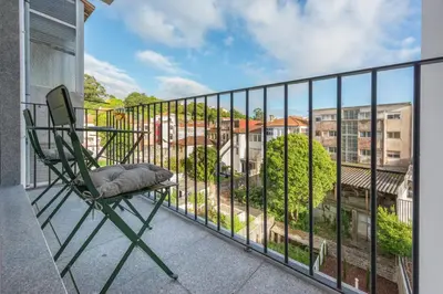 a green chair sitting on a balcony with a view at Paraíso Apartment in Porto