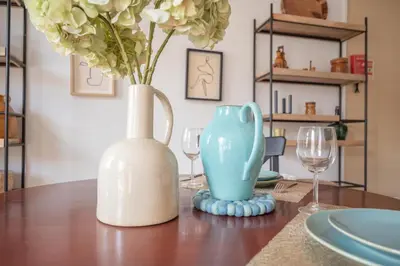 a table with a vase and two wine glasses at Fancy Ribeira Porto in Porto