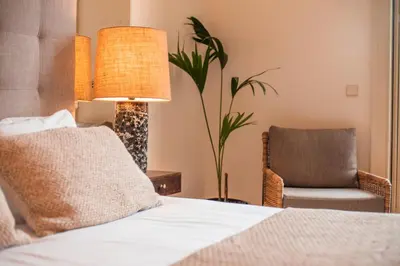 a bedroom with a bed with a lamp and a chair at Paraíso Garden Suite--- Spacious & Downtown in Porto