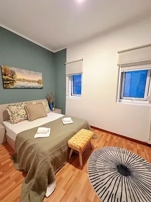 a bedroom with a bed and a ottoman at Downtown A whole house duplex designed for remote work and near metro lapa in Porto