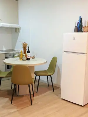 a kitchen with a table and a white refrigerator at Downtown A whole house duplex designed for remote work and near metro lapa in Porto