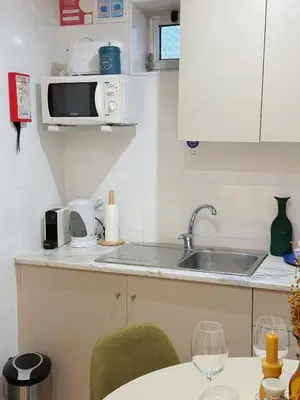 a kitchen with a sink and a microwave at Downtown A whole house duplex designed for remote work and near metro lapa in Porto