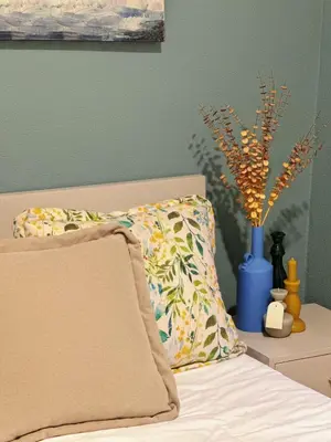 a bed with a pillow and a vase with flowers at Downtown A whole house duplex designed for remote work and near metro lapa in Porto