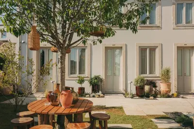 a patio with tables and stools in front of a building at Village By BOA in Porto