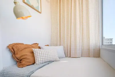 a pillow sitting on a couch next to a window at Santa Catarina Panoramic Loft in Porto