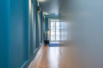 a bedroom with blue walls and a bed and a bathroom at Infante Apartment by Amber Star Rent in Porto