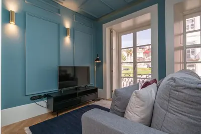 a living room with a couch and a flat screen tv at Infante Apartment by Amber Star Rent in Porto