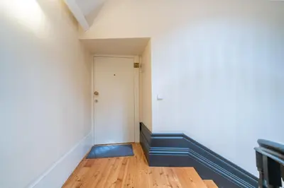 a small bedroom with a bed and a yellow chair at Mercadores Apartment by Amber Star Rent in Porto