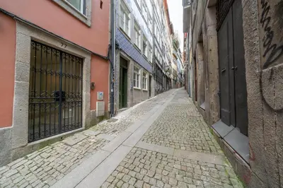 an empty street with an alley with buildings at Mercadores Apartment by Amber Star Rent in Porto