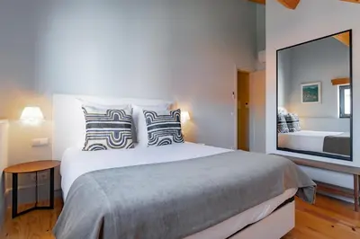 a bedroom with a large bed with a large mirror at My homey at Flores in Porto