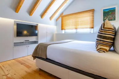 a bedroom with a large bed and a flat screen tv at My homey at Flores in Porto