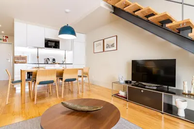 a living room with a table and a large television at My homey at Flores in Porto