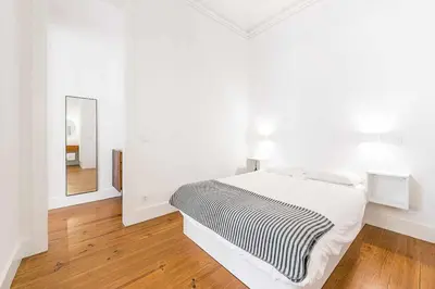 a white bedroom with a bed and a mirror at Classic Bonjardim in Porto