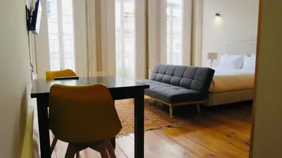 a room with a bed and a table and a couch at Porto Republica Ribeira in Porto