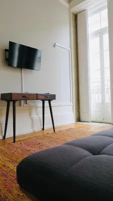 a room with a tv on a wall with a table at Porto Republica Ribeira in Porto