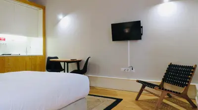 a bedroom with a bed and a tv on the wall at Porto Republica Ribeira in Porto