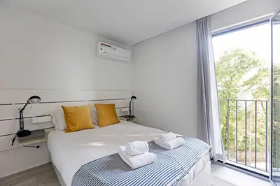 a bedroom with a bed and a large window at Stylish Flat W/ Gym & Parking by LovelyStay in Porto