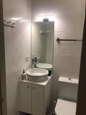 a bathroom with a sink and a toilet and a mirror at Pateo Loft in Porto