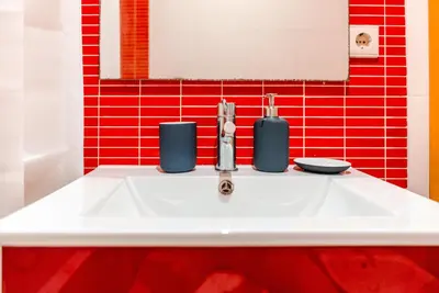 a white sink in a bathroom with red tiles at Taupe Studio perto do Metro - Cedofeita, Porto in Porto