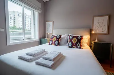 a bedroom with a bed with three towels on it at Taupe Studio perto do Metro - Cedofeita, Porto in Porto
