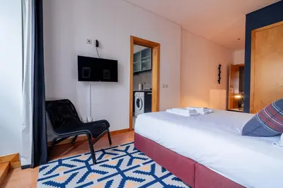 a hotel room with a bed and a chair at Blue Studio perto do metro - Cedofeita, Porto in Porto