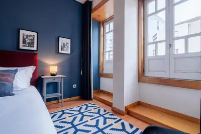 a bedroom with blue walls and a bed and a window at Blue Studio perto do metro - Cedofeita, Porto in Porto