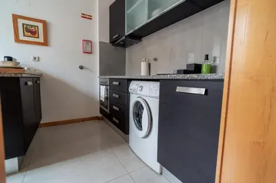 a kitchen with a washer and dryer in it at Blue Studio perto do metro - Cedofeita, Porto in Porto