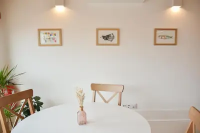 a white table with a vase of flowers on it at Charmosa penthouse 2 quartos - Batalha - Porto - APT N in Porto
